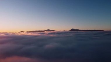 Yüksek dağları gören kabarık bulutlarda uçmak
