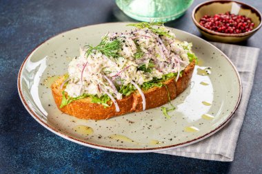 Beyaz yuvarlak tabakta yaban mersinli sandviç ve omlet.