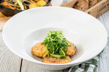 Dekorla çekilen yuvarlak bir tabakta birkaç nohut pirzolası.