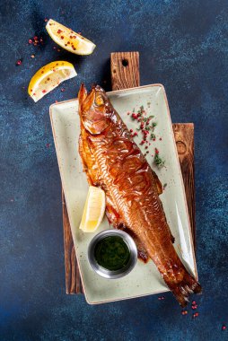 Limonlu füme alabalık, menü için beyaz tabakta sos.