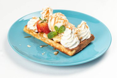 Dondurmalı waffle, muzlu çilek, yakın plan bir tabakta.