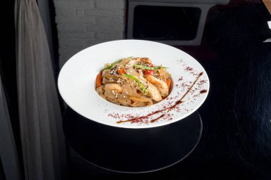 Beyaz bir tabakta taze otlu, etli cam şehriye.