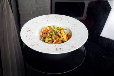 Siyah arkaplana karşı beyaz tabakta domuz kulağı.