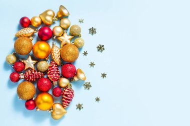 Kırmızı ve altın renkli mavi arka planda Noel oyuncakları olan bir arka plan. Balonlar, yıldızlar, çanlar, kar taneleri ve koniler. Yeni yıl, Noel