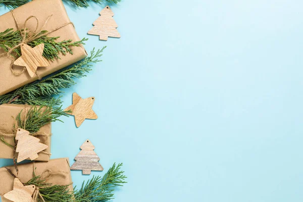 Composición navideña. Regalos de Navidad, ramas de abeto, adornos de madera sobre un fondo azul. Piso tendido, vista superior, espacio para copiar. Año Nuevo — Foto de Stock