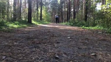 Gündüz vakti bir kadın sonbahar ormanında koşar..