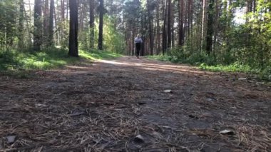 Bir kadın güz ormanlarında gündüz ağır çekimde koşar..