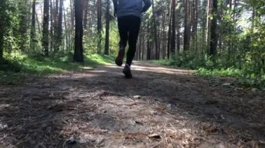 Erkek sporcu ormanda koşar. Yavaş çekim.