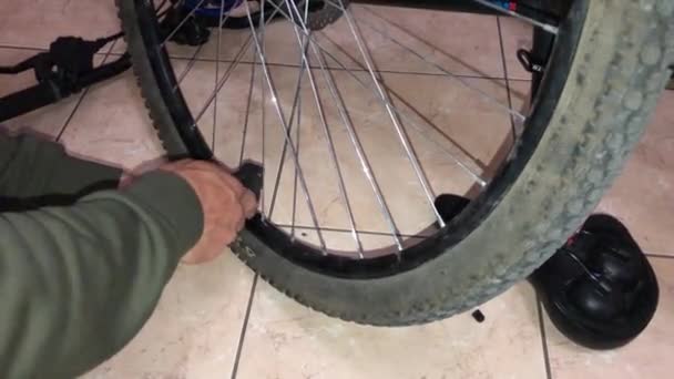 Чоловік підкачує гірське велосипедне колесо — стокове відео