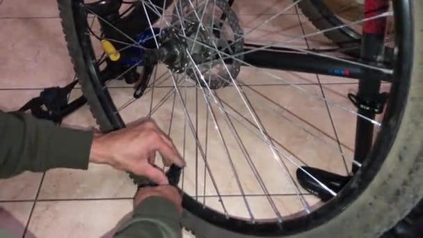 한 남자가 산에 달린 자전거 바퀴를 들어올리고 있다 — 비디오