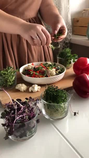 Mujer añade brotes a una ensalada de verduras saludables — Vídeos de Stock