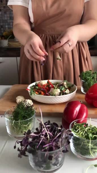 Mujer añade brotes a una ensalada de verduras saludables — Vídeos de Stock