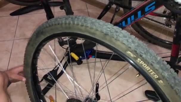 Чоловік повертає шину на велосипед — стокове відео