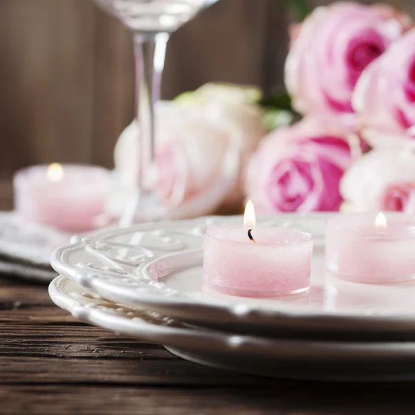 Roze kaarsen en de rozen op tafel — Stockfoto