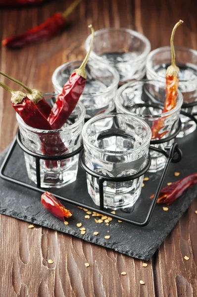 Перец чили и стаканы водки — стоковое фото
