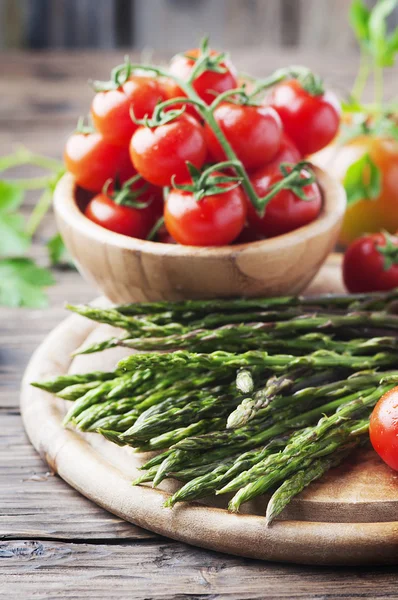 Raw fresh asparagus with tomatoes — Stock Photo, Image