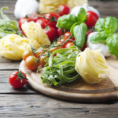 Pişmemiş makarna, domates ve fesleğen ahşap tablo