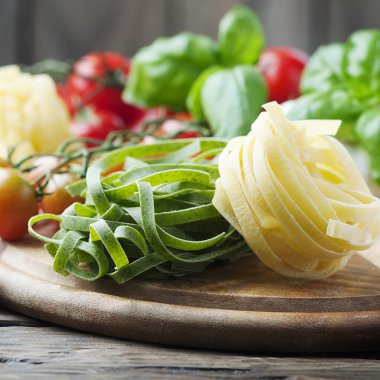 Pişmemiş makarna, domates ve fesleğen ahşap tablo