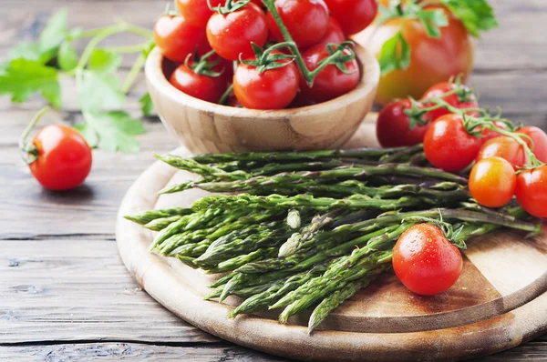 Uncooked fresh asparagus with tomatoes — Stock Photo, Image