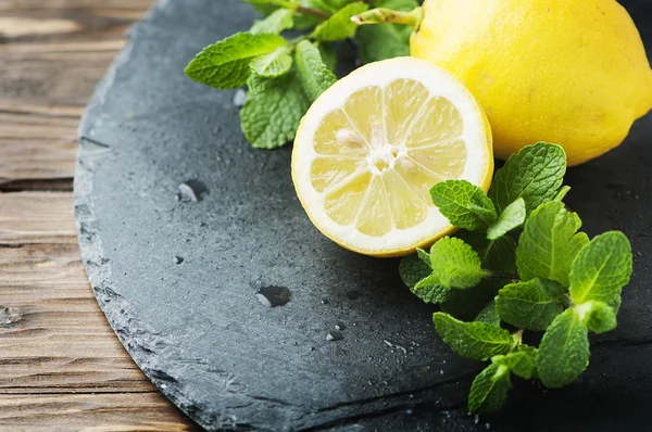 Limón amarillo y menta verde sobre la mesa — Foto de Stock