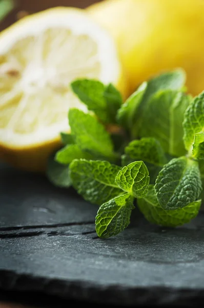 Gele citroen en groene munt op tafel — Stockfoto