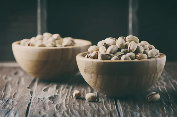 Salt pistachio nuts in the wooden bowl — Stock Photo, Image
