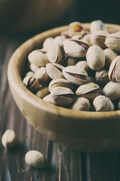 Соленые фисташковые орехи в деревянной чаше — стоковое фото