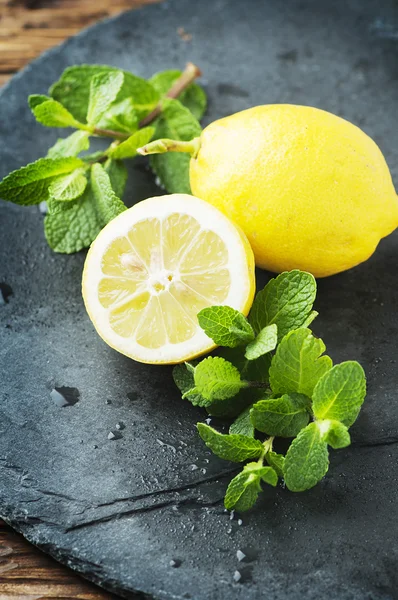 Limão amarelo e hortelã verde na mesa — Fotografia de Stock