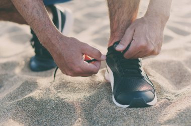 Gün batımı kumsalda koşan yakışıklı adam