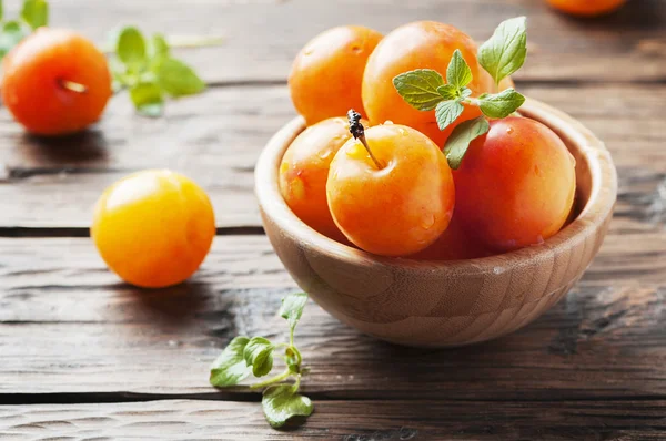 Ripe plums in wooden bowl — Stock Photo, Image