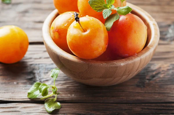 Ripe plums in wooden bowl — Stock Photo, Image