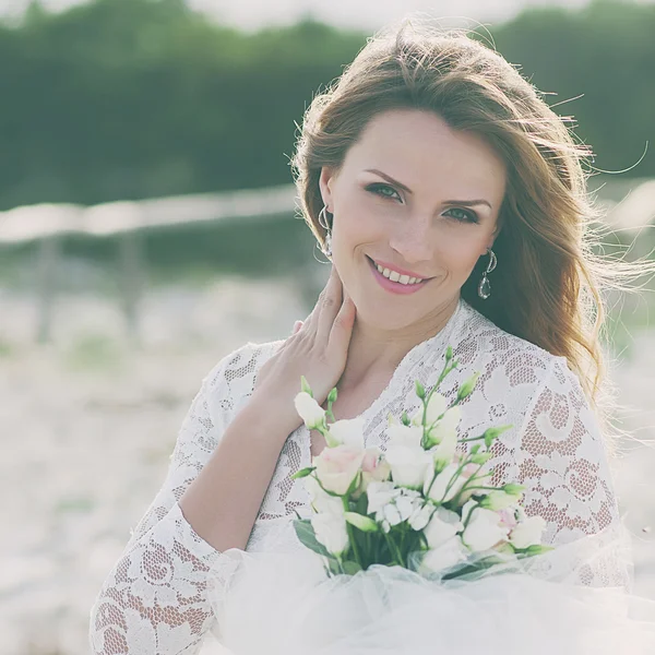 Glückliche junge Frau im Hochzeitskleid — Stockfoto