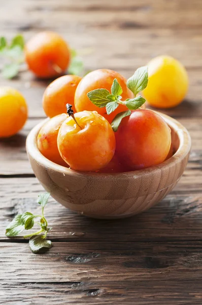 Ripe plums in wooden bowl — Stock Photo, Image