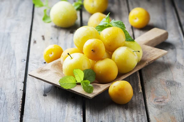 Prunes jaunes sur planche à découper — Photo