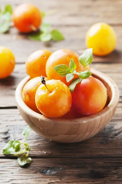 Ripe plums in wooden bowl — Stock Photo, Image