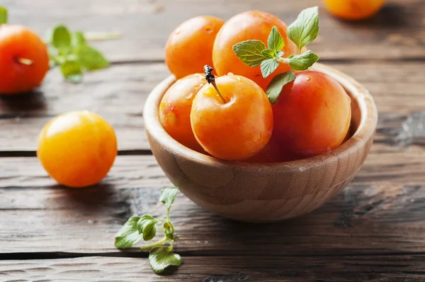 Ripe plums in wooden bowl — Stock Photo, Image