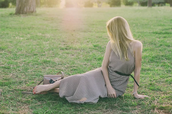 Jeune femme dans le parc du coucher du soleil — Photo