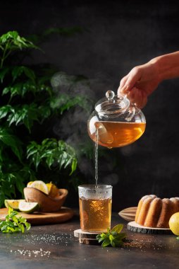 Kadın siyah arka plana sıcak bir siyah çay koydu, seçici odak görüntüsü.