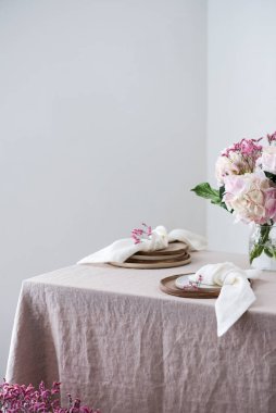 El yapımı seramik tabaklar ve keten masa örtüsü ve çiçekler. Parti konsepti