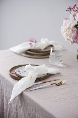 El yapımı seramik tabaklar ve keten masa örtüsü ve çiçekler. Parti konsepti