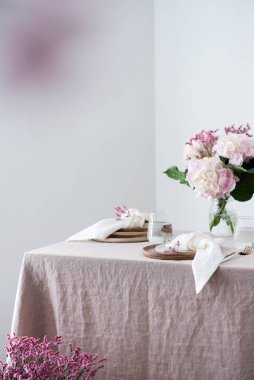 El yapımı seramik tabaklar ve keten masa örtüsü ve çiçekler. Parti konsepti