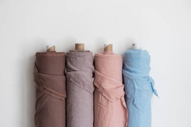 Kumaş dükkanı konsepti. Aydınlık duvarda farklı renkte çarşaf ruloları, odak resmini seç