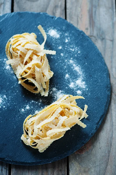 Pâtes italiennes crues traditionnelles sur la table en bois — Photo