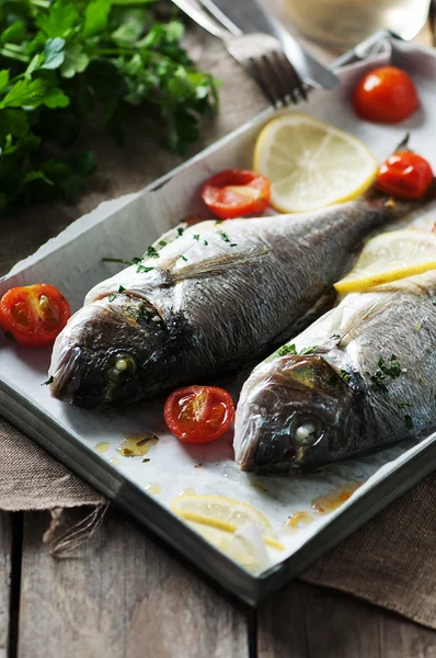 Cooked fish with parsley, tomato and lemon