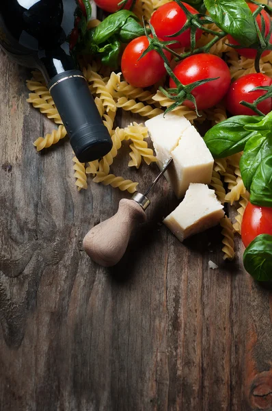 Italian food with raw fusilli, tomato, basil, cheese — Stock Photo, Image