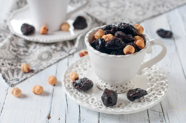 Dried plums and nuts in white cup — Stock Photo, Image