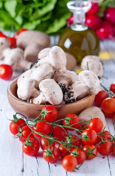 Mushrooms, a bottle of oil and fresh vegetables — Stock Photo, Image