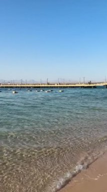 Hurghada, Kızıldeniz, Mısır 'ın kumlu sahilinde kristal berrak turkuaz su 4k dikey çekim.