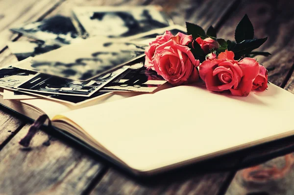Фотоальбом с розами на деревянном столе — стоковое фото