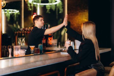 Barmenin biriyle beşlik çaktığı canlı bir kokteyl barı..